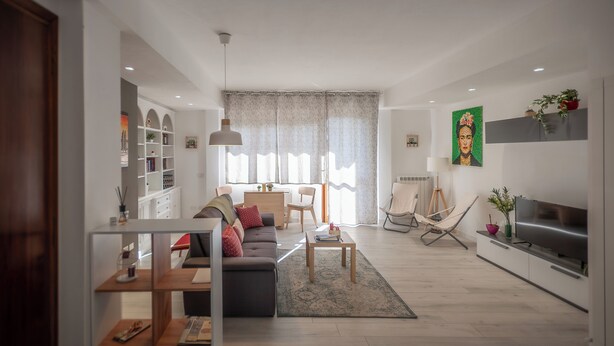 Ein modernes Wohnzimmer mit Sofa, Couchtisch und Fernseher.
