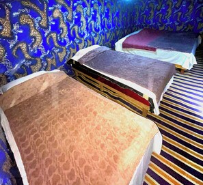 Habitación de hotel con dos camas, un papel tapiz estampado y una alfombra a rayas.
