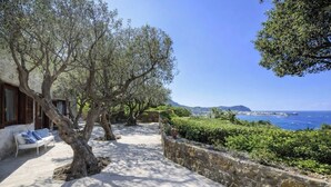 A coastal property with a stone wall, outdoor seating, and a view of the sea. - Villa Grotta Leone (Campania)