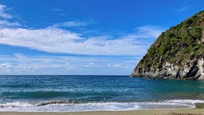 A coastal beach with clear skies and calm waters. - Villa Grotta Leone (Campania)