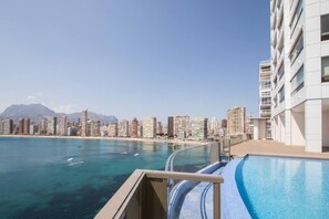 Un hotel moderno con piscina que ofrece vistas a una ciudad costera.