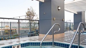A hot tub with a 3-foot depth, surrounded by a tiled deck and metal railings. - Family sized 2 BR, 2 Bath, 6 guest resort condo 5 minutes to Disneyland (Anaheim)