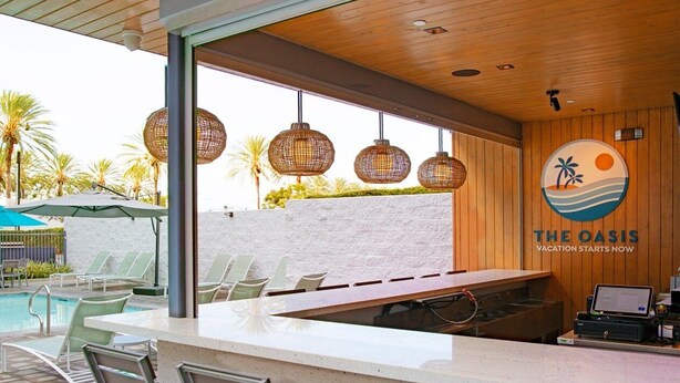 An outdoor bar area with a pool, lounge chairs, and a wooden ceiling. - Family sized 2 BR, 2 Bath, 6 guest resort condo 5 minutes to Disneyland (Anaheim)
