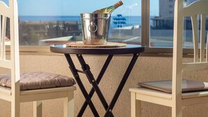 A balcony with a table, two chairs, and a bucket with a bottle. - Apto 4 pax  a 2 minutos playa.A/C,terraza.Piscina. (La Vila Joiosa)
