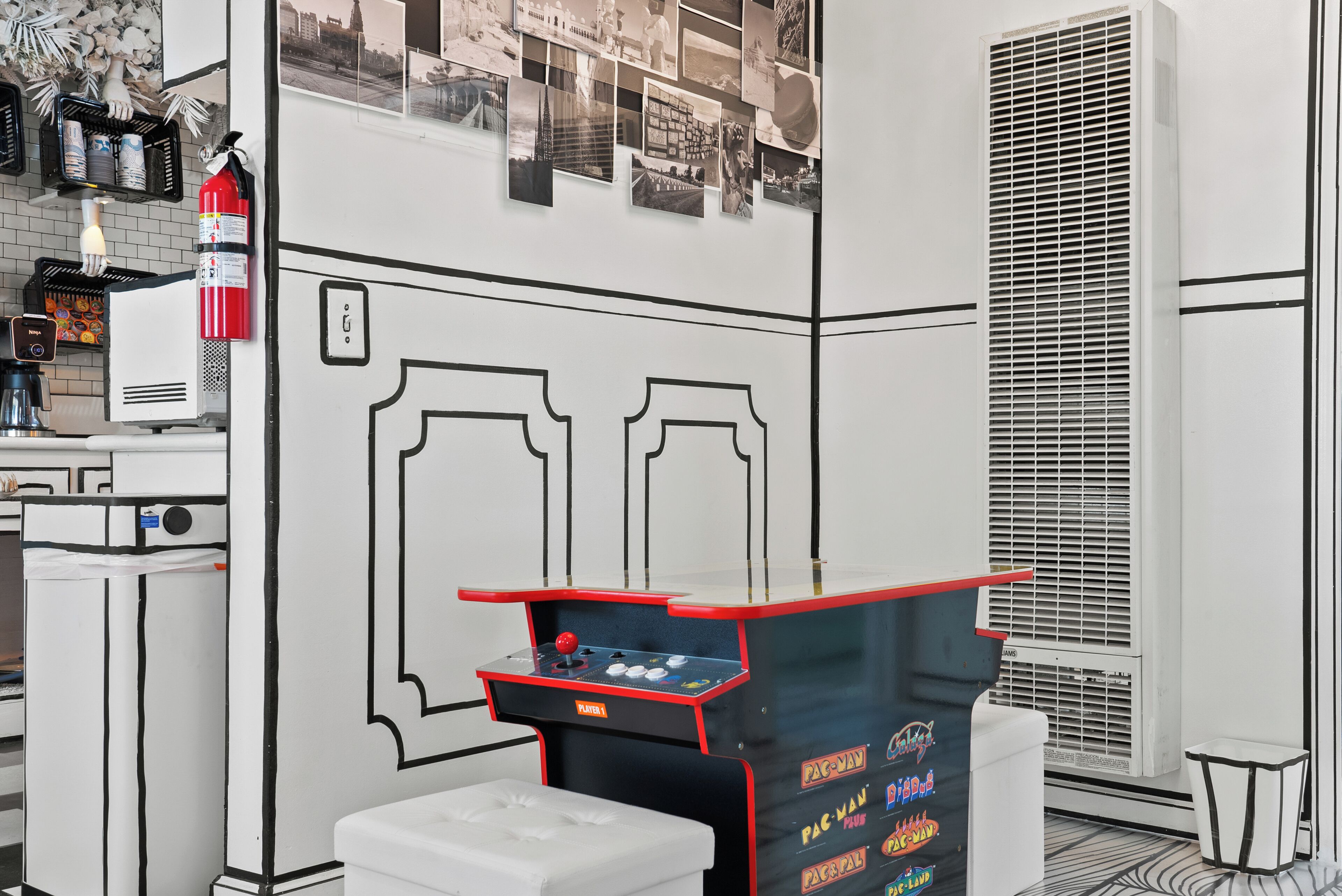 A kitchenette with a coffee machine, a fire extinguisher, and a wall-mounted air conditioning unit.
