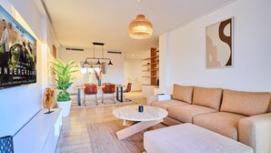 Una sala de estar moderna con sofá, mesa de centro y comedor.