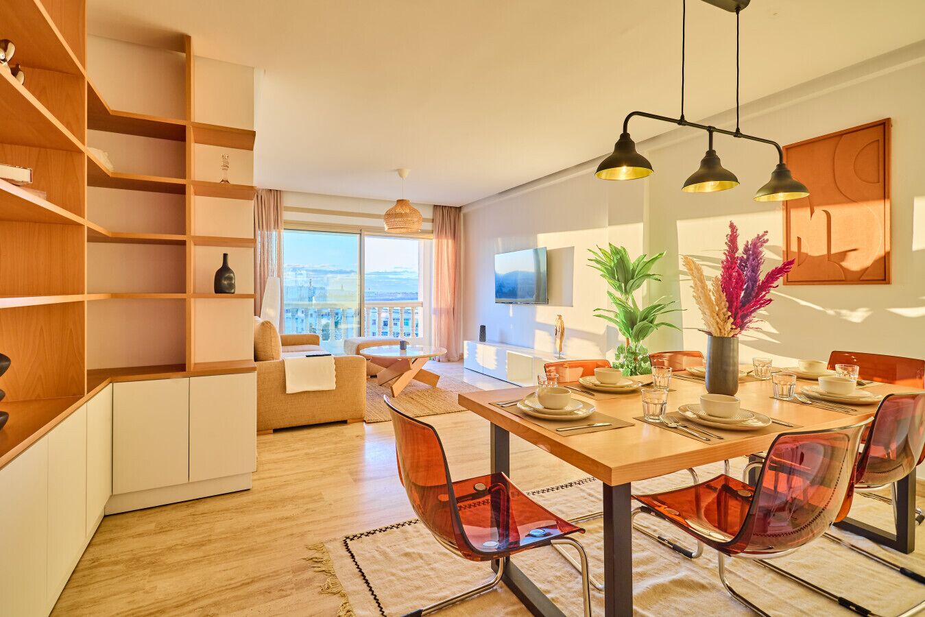 Un espace repas moderne avec une table en bois, des chaises transparentes et une vue sur la ville.