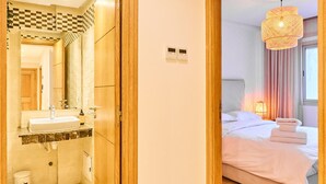 Habitación de hotel con baño, cama y un espejo grande.