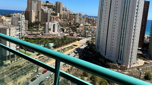 A high-rise building with multiple floors, a clear view of the surrounding cityscape, and a distant coastline.