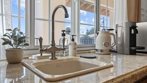A kitchen with a sink, faucet, coffee maker, and a potted plant. - Bella Notte by the beach Studio 8 (Pleasure Point)