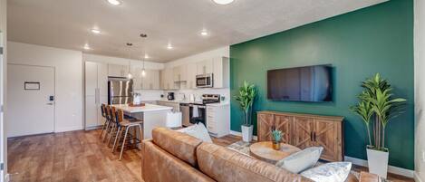 A modern apartment with a kitchen, dining area, and living room.