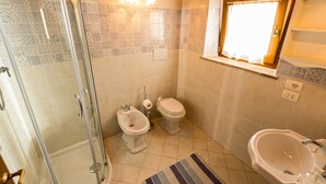 Un bagno dotato di doccia, WC, bidet e vasca da bagno.