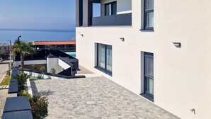 Un edificio moderno con techo plano, ventanas amplias y vista al mar.