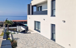 A modern building with a flat roof, large windows, and a view of the sea. - Villa Mandre Hills II (Mandre)