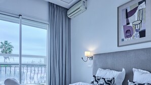 Ett hotellrum med en stor säng, utsikt från fönstret och en tavla på väggen.