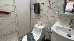 Un baño moderno con inodoro, bidé y lavamanos.