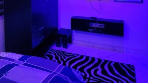 Ein Zimmer mit einem Bett, einem Schrank, einem Fernseher und einem Spiegel.