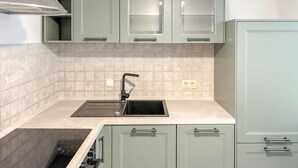 Een keuken met een spoelbak, kastjes en een aanrecht.