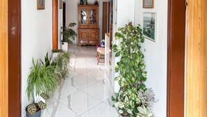 A hallway with a wooden cabinet, potted plants, and a chair. - Gorgeous apartment in Rab with house sea view (Rab)