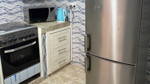 Una cocina con refrigerador de acero inoxidable, microondas y horno.