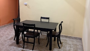 Un área de comedor con una mesa y sillas, un ventilador de techo y un interruptor de luz en la pared.
