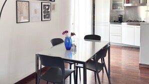 Eine moderne Küche mit weißen Schränken, einer Edelstahl-Dunstabzugshaube und einem Gasherd.
