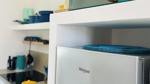 A kitchen with a microwave on top of a Whirlpool refrigerator. - 100mt from the sea of San Foca di Melendugno (San Foca)