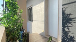 A modern interior with a potted plant, a window, and a door. - 100mt from the sea of San Foca di Melendugno (San Foca)