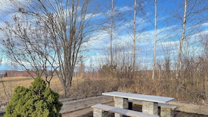 A picnic table with benches, surrounded by a brick wall and a small evergreen tree. - Villa Heed (Tallberg)
