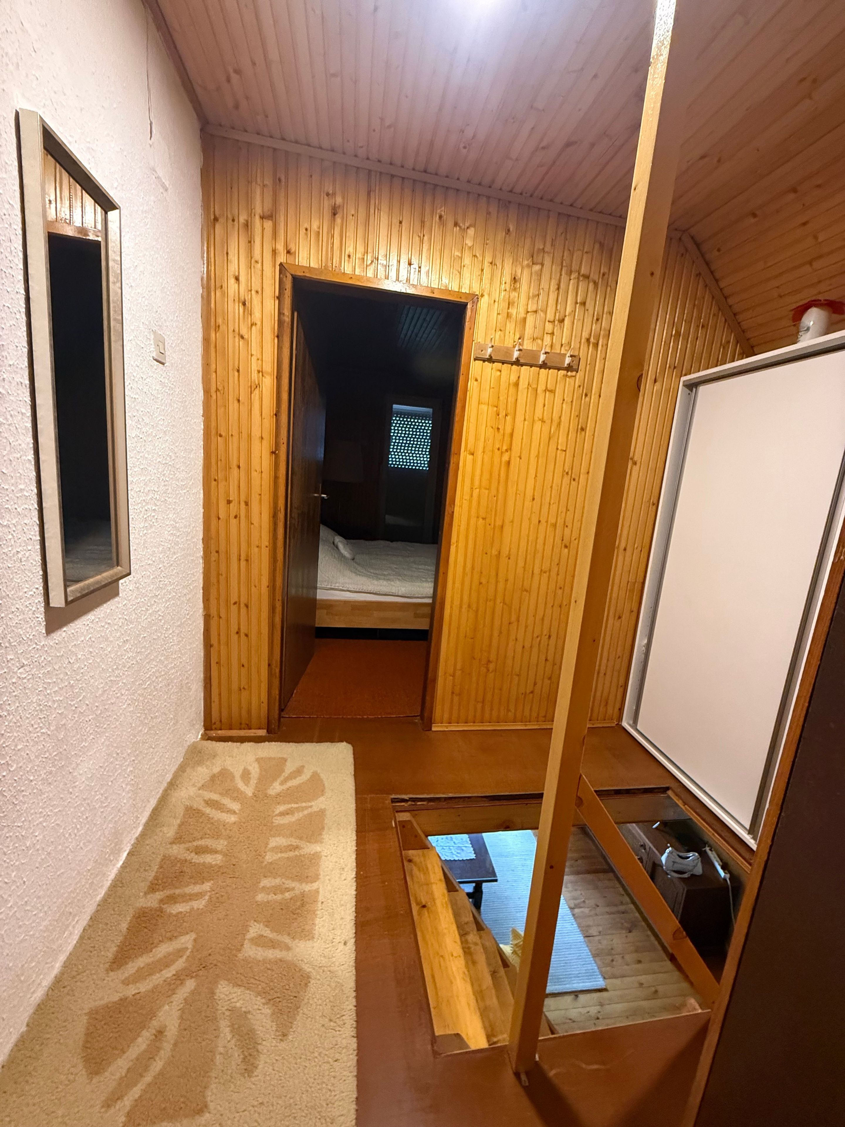 Una stanza compatta con un letto, un tavolino e una lavagna.