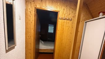 Una stanza compatta con un letto, un tavolino e una lavagna.