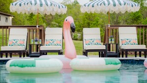 A pool with lounge chairs and a flamingo float. - Rolling Ridge | Sleeps 23, GameRoom, Pets, Sauna, HeatedPool, Theater, & More (Laurelville)