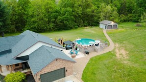 A residential property with a swimming pool, hot tub, and deck area. - Rolling Ridge | Sleeps 23, GameRoom, Pets, Sauna, HeatedPool, Theater, & More (Laurelville)