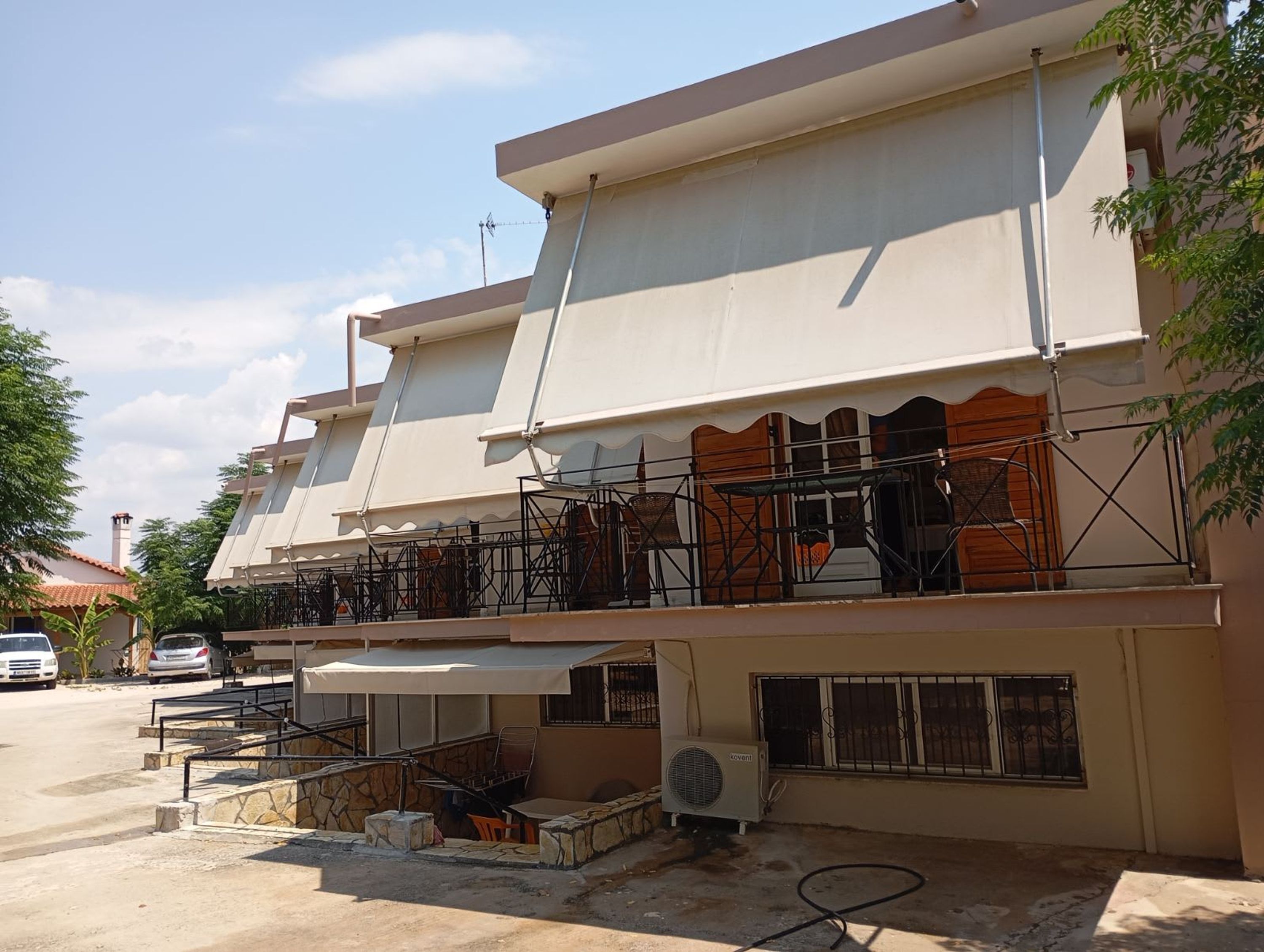 A building with a flat roof, outdoor seating, and a visible air conditioning unit.