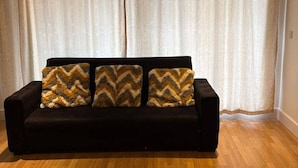 A black sofa with three patterned throw pillows against a backdrop of sheer curtains. - London Brigde Luxurious Spacious Apartment (London)