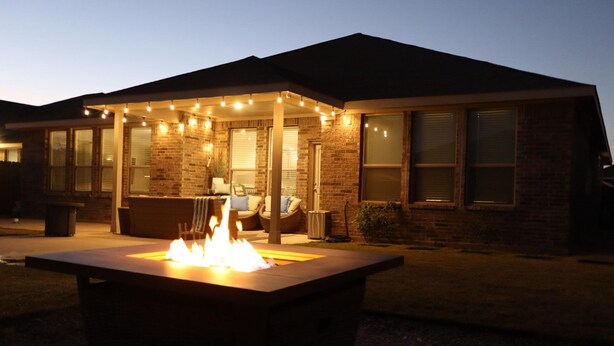 A house with a fire feature in the front yard, a covered patio area, and a brick exterior. - 4-bedroom house in adorable Midland  (Midland)