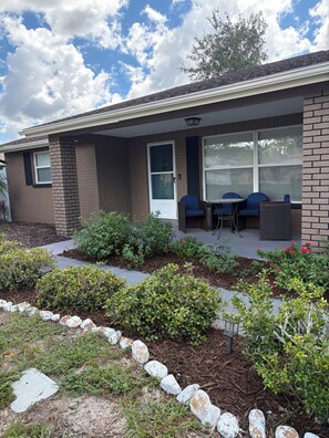 A residential building with a covered porch, a door, and a window. - 3-bedroom house in Holiday,FL with a beautiful pool oasis. Pool is heated (Holiday)