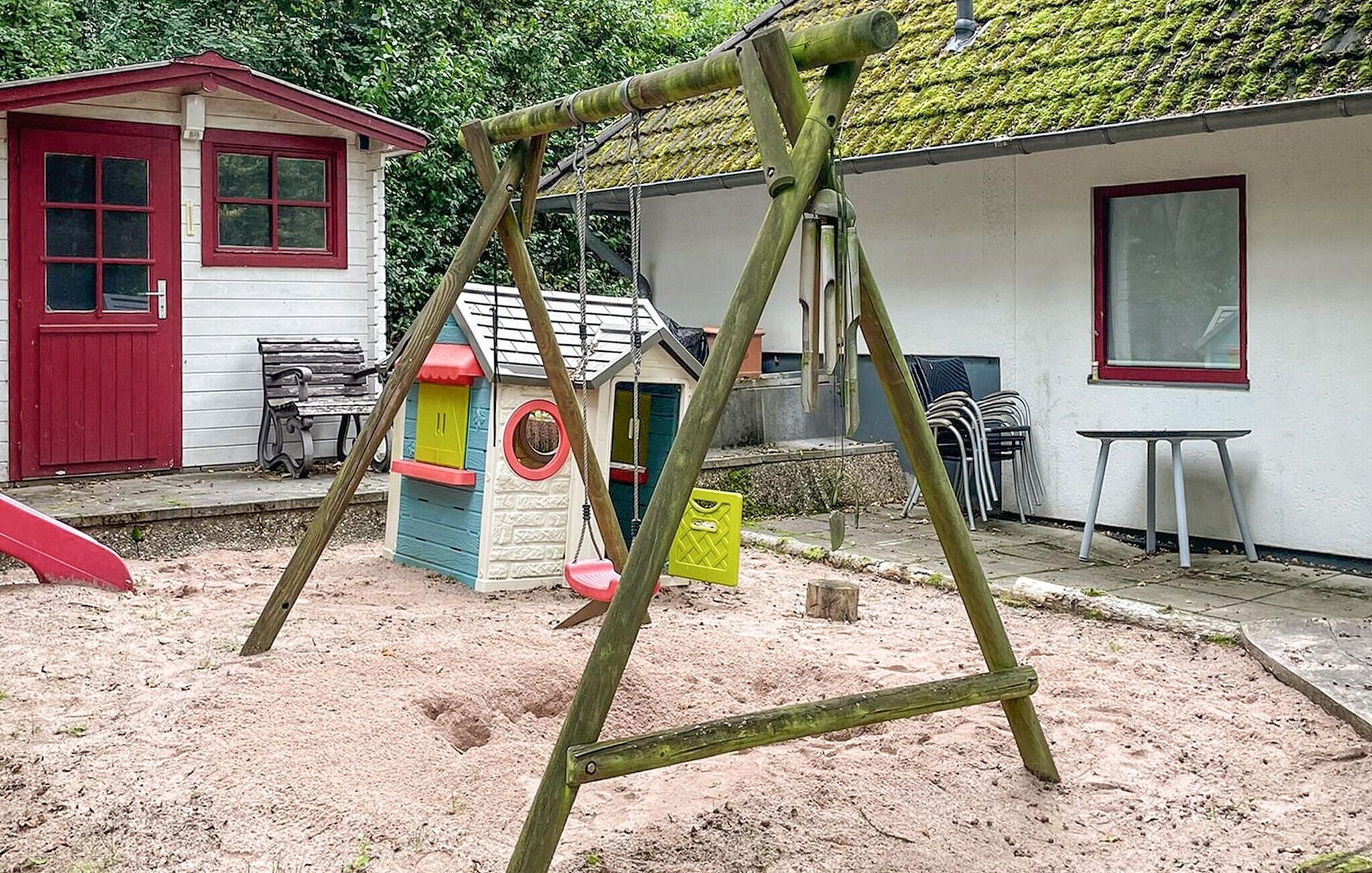 A playground with swings and a small playhouse.