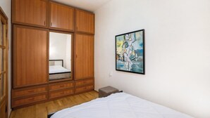 Ein Schlafzimmer mit einem Bett, einem Holzschrank und einem Bild an der Wand.