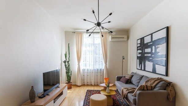Ein modernes Wohnzimmer mit Sofa, Fernseher und Dekorationselementen.