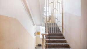 Eine Treppe mit Metallgeländer, Handlauf und einer Tür am oberen Ende.