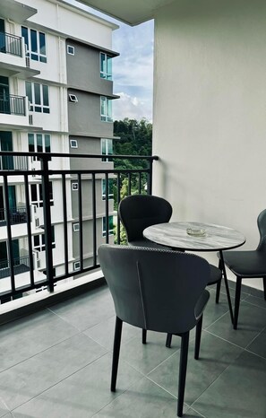 A balcony with a round table and two chairs, a view of a multi-story building, and a tiled floor. - Comfortable , near shop and quiet.. (Sandakan)