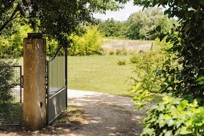 A gated entrance to a property with a gravel path leading through it. - Maison Margerie - Provencal farmhouse with swimming pool and view of Mont Ventoux (Colonzelle)