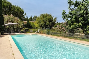 A rectangular swimming pool with clear water, surrounded by a concrete deck. There are lounge chairs and a single umbrella. - Maison Margerie - Provencal farmhouse with swimming pool and view of Mont Ventoux (Colonzelle)
