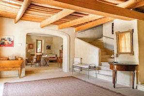 A room with a wooden ceiling, a staircase, a bed, a small table, and a mirror. - Maison Margerie - Provencal farmhouse with swimming pool and view of Mont Ventoux (Colonzelle)