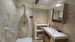 Un baño moderno con ducha, lavabo y espejo.