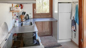 Una cucina compatta con lavandino, bollitore e frigorifero.