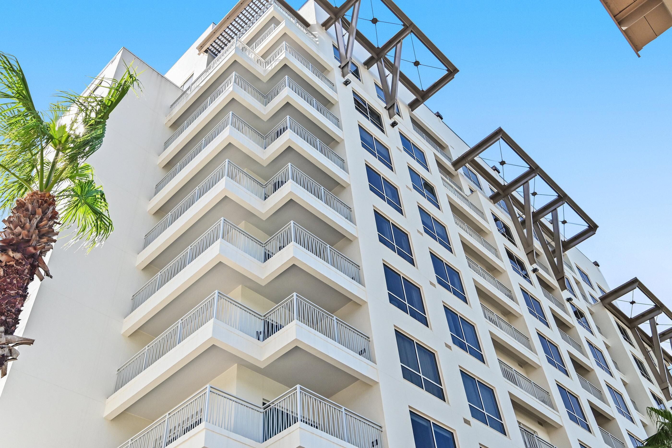 A multi-story hotel with balconies and large windows.