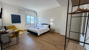 Une chambre à coucher moderne avec un lit, une table de chevet et un bureau avec une chaise.