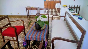 A dining area with a checkered floor, a table with a striped tablecloth, and wooden chairs. - Strategic and centrally located apartment in Magdalena del Mar (Magdalena del Mar)